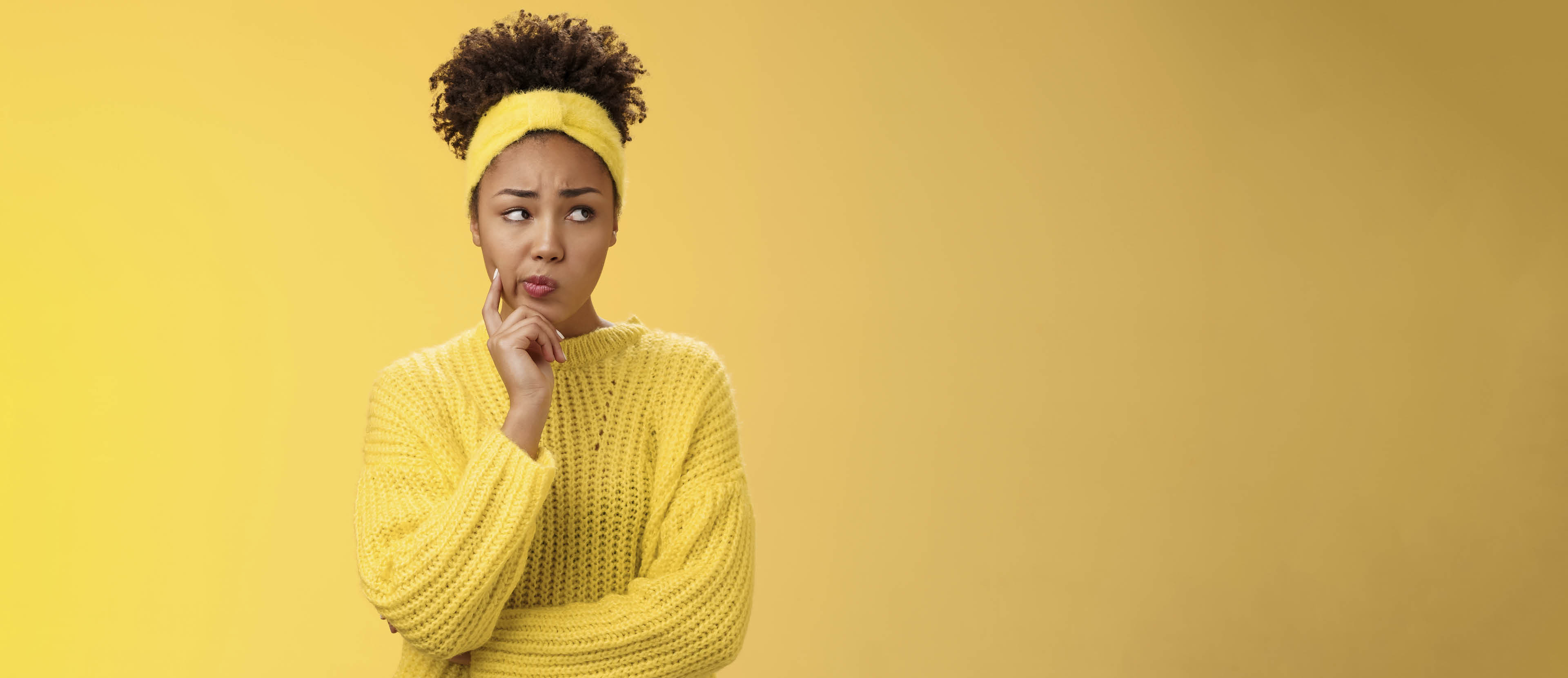 Perplexed unsure cute timid african-american female thinking how escape awkward situation smirking frowning concerned touch cheek thoughtful thinking nervously, worried yellow background.
